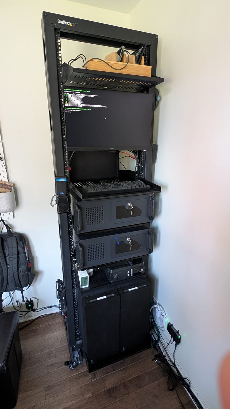 Le rack vu de face : l’écran du kiosque en haut avec un terminal, la tablette du clavier, puis les deux boîtiers Rosewill 4U noirs, chacun sur sa tablette